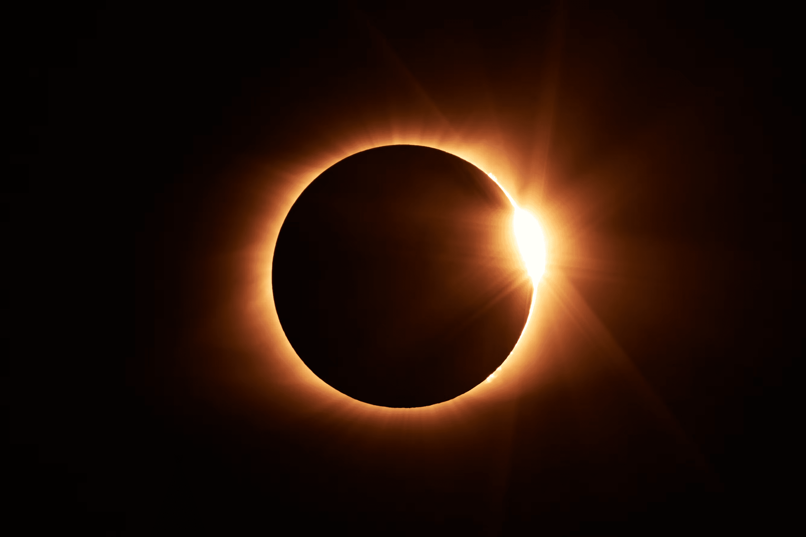 Bright diamond-ring effect at the edge of the Moon during a solar eclipse.