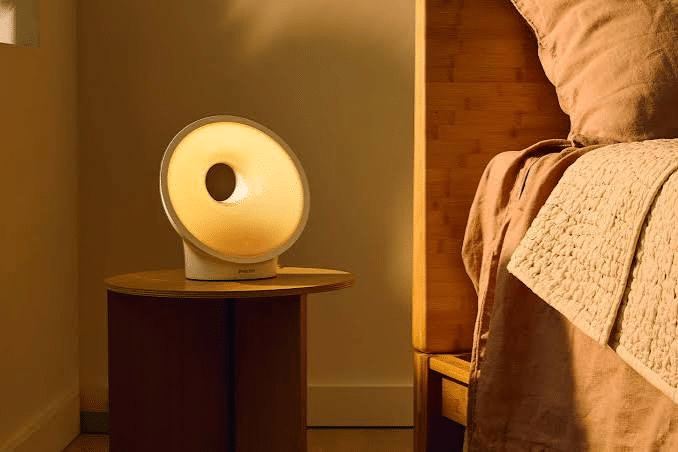 Warm glowing sunrise alarm clock on a bedside table