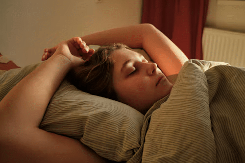 Person resting in bed in warm evening light